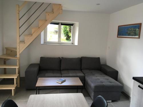 sala de estar con sofá y mesa de madera en la violette, en Gouville-sur-Mer
