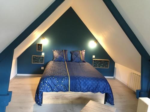 a bedroom with a blue bed in a attic at la violette in Gouville-sur-Mer