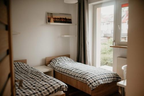 - 2 lits dans une petite chambre avec fenêtre dans l'établissement Dom na Lawendowej, à Głuszyca