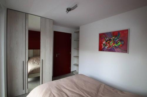 1 dormitorio con 1 cama y una pintura en la pared en L'Aurore, en Gérardmer