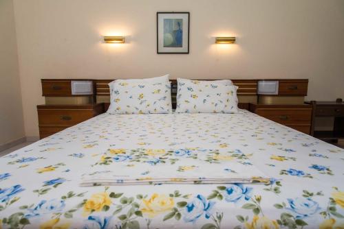 ein Bett mit blauen und gelben Blumen darauf in der Unterkunft Fokion Studios in Lakíthra