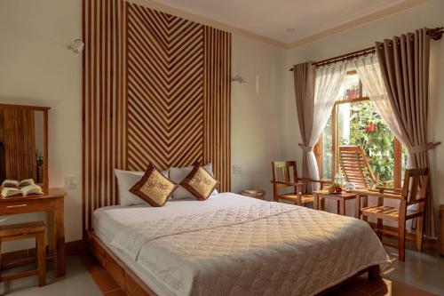 a bedroom with a bed and a window at Little Garden Bungalow in Phu Quoc