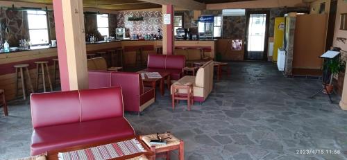 un restaurante con sillas rojas y un bar en Hotel Konstantina, en Rodópolis