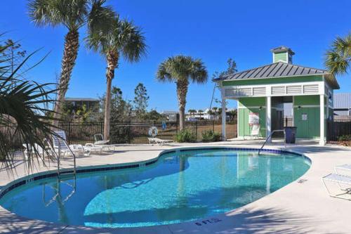 uma piscina com um gazebo e palmeiras em Stella Maris em Mexico Beach