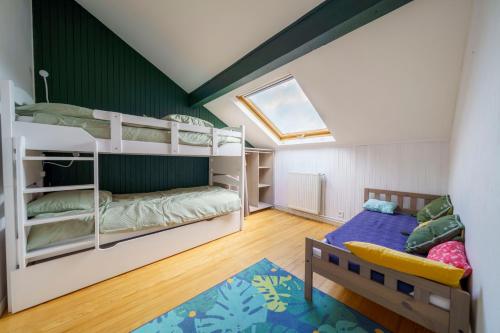 Habitación infantil con literas y ventana en Gîte avec piscine chauffée & aires de jeux pour enfants, en Barberaz