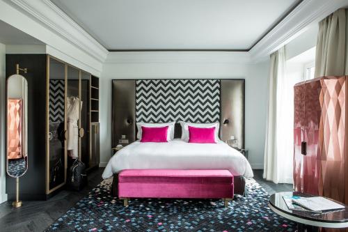Fauchon l'Hôtel Paris في باريس: غرفة نوم مع سرير كبير مع وسائد وردية