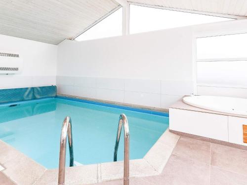 a swimming pool in a bathroom with a tub and a sink at 12 person holiday home in Pandrup in Rødhus