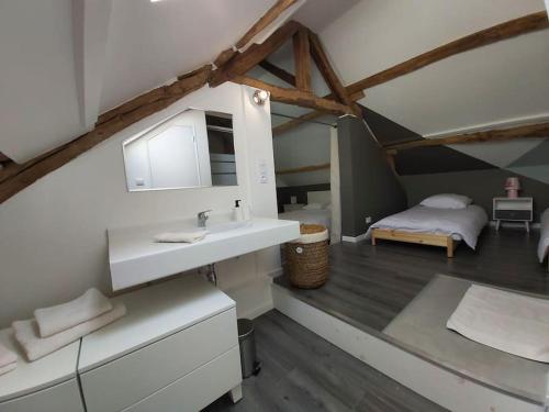 a bathroom with a sink and a bed in a room at Cosy &Jolie Maison tout à coté de DisneyLand Paris in Montry