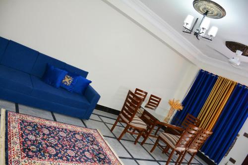 a living room with a blue couch and a table at Khyber Guest House Swat in Saidu