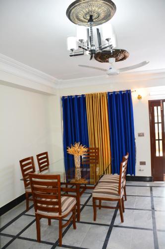 a dining room with a table and chairs and a chandelier at Khyber Guest House Swat in Saidu
