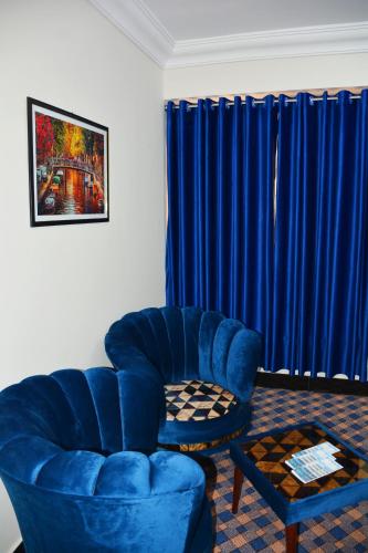 a living room with a blue chair and a table at Khyber Guest House Swat in Saidu
