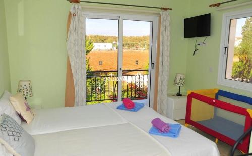 a bedroom with a bed and a large window at LULA VILLA in Ayia Napa