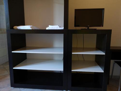 a black book shelf with a television on top at Diecizero Affittacamere in Barùmini