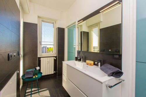 La salle de bains est pourvue d'un lavabo blanc et d'un miroir. dans l'établissement Al 4, à Busto Arsizio