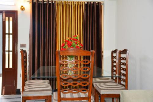 a dining room with a glass table and chairs at Khyber Guest House Swat in Saidu