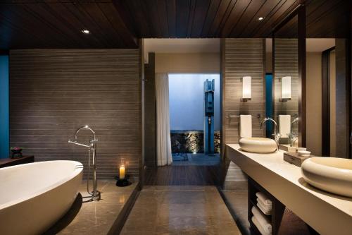 a bathroom with two sinks and a bath tub at Raffles Hainan Clear Water Bay in Sanya