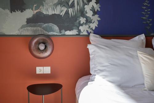 ペルヌ・レ・フォンテーヌにあるHôtel La Pernaのオレンジ色の壁のベッドルーム(ベッド1台、椅子付)