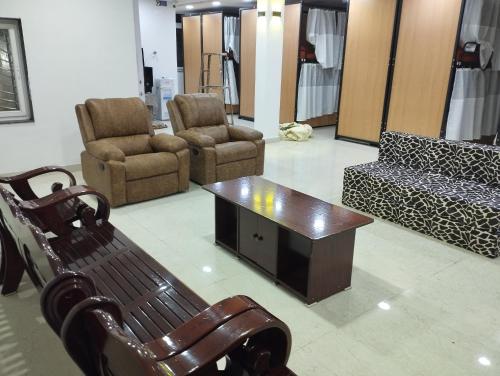 ein Wohnzimmer mit einer Bank, Stühlen und einem Tisch in der Unterkunft RDA Dormitory in Raipur