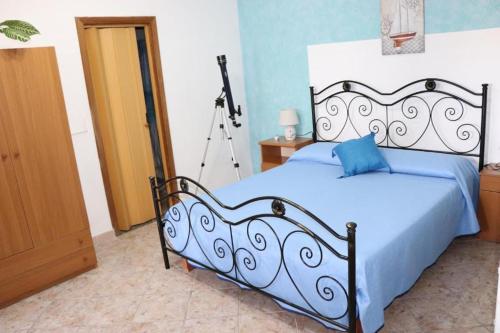 a bedroom with a bed with a blue blanket and a camera at Casa Vacanza Villa Sole in Siculiana