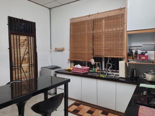 a kitchen with a black counter and a table at T'Rai Homestay in Dungun