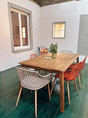 une table et des chaises en bois avec une plante en pot dans l'établissement Appartement chaleureux au centre du village, à Montesquieu-Volvestre