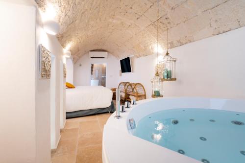 a bathroom with a tub and a bedroom with a bed at Apulia Charming Suites - Casa Lonfo Suite Sole in Monopoli