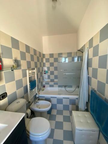 a bathroom with a toilet and a sink and a tub at Bella Vista in Syracuse