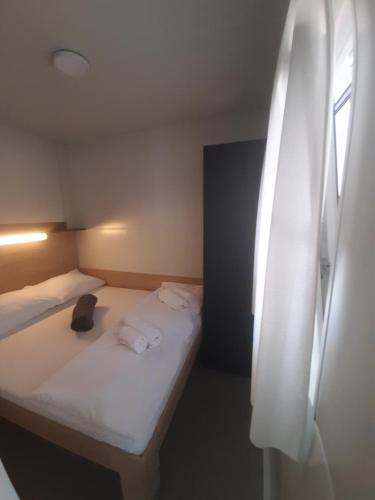 a room with two beds with towels and a window at Mobilna kuća T&D in Privlaka