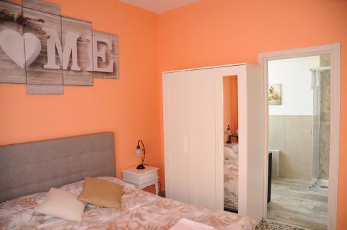 una camera da letto con pareti arancioni, un letto e uno specchio di Andrea affittacamere e B&B a Solignano Nuovo