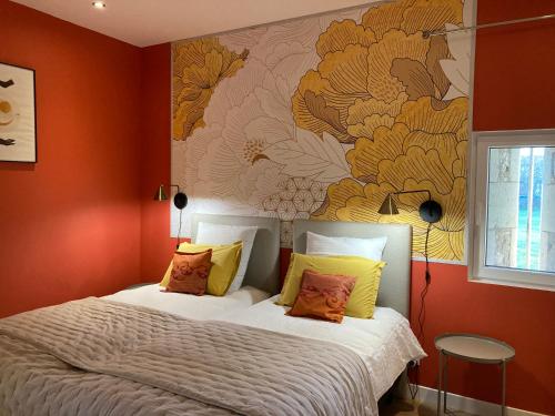 a bedroom with a bed with orange walls at Le Manoir des Sables - Chambre familiale grand confort in Berthegon