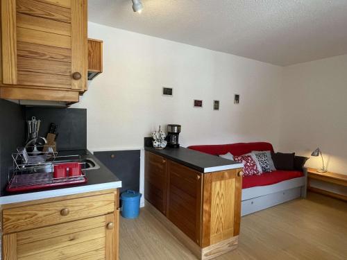 - une cuisine avec un canapé rouge dans une chambre dans l'établissement Studio 4 pers, pied de pistes à Chantemerle, Wi-Fi, proche commerces - FR-1-330E-49, à Serre Chevalier