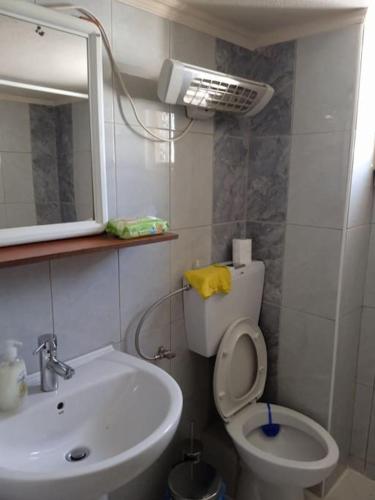 a bathroom with a sink and a toilet and a mirror at Πουτουρίδου Αλεξάνδρα in Paralia Katerinis