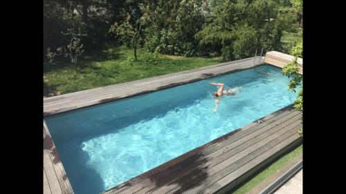 una mujer en una piscina con una persona en el agua en Über den Dächern von Koblenz - Aussichts-Wohnung Naturpark Rheinblick, ruhig, zentrumsnah, Sport-Pool, en Coblenza