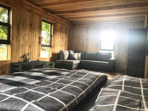 a bedroom with a bed and a couch at Modern Barn Home & Sauna by the lake, przytulnastodola, Stodoła nad jeziorem na Mazurach in Ełk