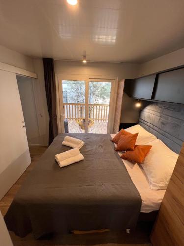 a bedroom with a large bed with two towels on it at Mobile Home Bubamara in Drage