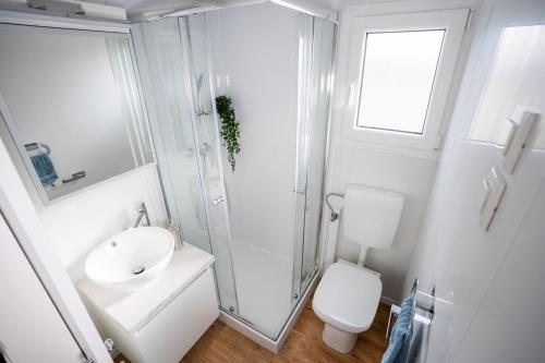 uma casa de banho com um chuveiro, um lavatório e um WC. em Mobile Home Bubamara em Drage