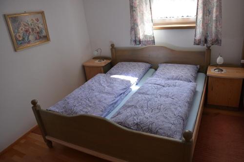 a bedroom with a bed with purple sheets and a window at Holzhaus in Hauzenberg