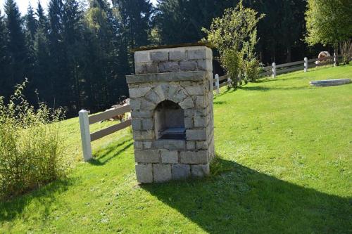 a stone oven in the middle of a field at Holzhaus in Hauzenberg