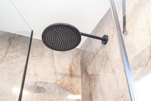 a shower with a black shower head in a bathroom at Villas Residence 360 in Trogir