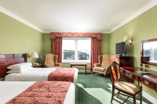 a hotel room with two beds and a television at Fernhill Hotel in Portpatrick