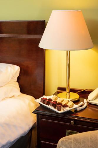 a table with a lamp and a plate of brownies on it at Fernhill Hotel in Portpatrick