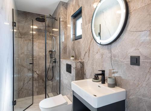 ein Bad mit einem Waschbecken und einer Dusche in der Unterkunft Villas Residence 360 in Trogir