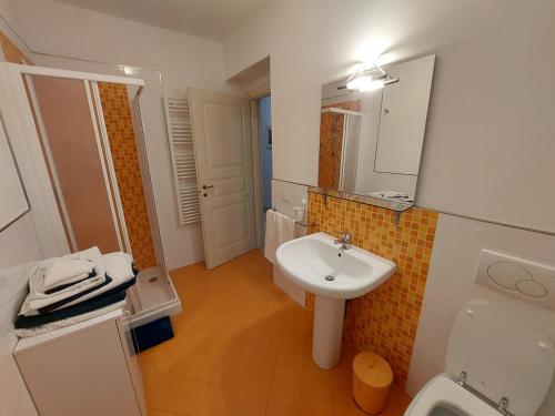 een badkamer met een wastafel, een toilet en een spiegel bij the waterfront refuge - Il rifugio frontemare in Pietrasanta