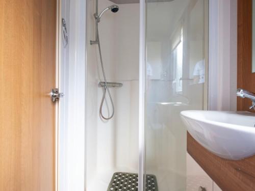 a shower with a glass door next to a sink at Thorpe Park Pass the Keys in Cleethorpes