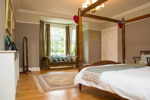 Setchey的住宿－The Grange Manor House, Norfolk，一间卧室配有一张床,窗户配有一张沙发