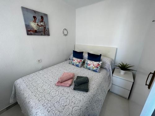 een slaapkamer met een bed met kussens en een foto bij Torrox Costa Mar in Torrox Costa