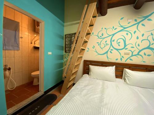een slaapkamer met een stapelbed en een badkamer bij 金門玉宿古厝小包棟民宿 in Jinhu