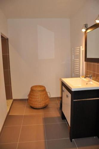 La salle de bains est pourvue d'un lavabo et d'un tabouret en osier. dans l'établissement La Grande Maison Rouge, à Mèze