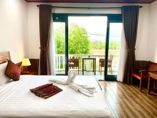 a hotel room with a bed with towels on it at Hoi An Sun Lake Villa in Hoi An