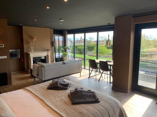 a bedroom with a large bed and a living room at Suite & Wellness in Breskens